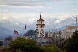 一座高大的白色砖顶钟楼矗立在一座多山的城市中, 靠近Equity group提供Kings Countymg冰球突破豪华版试玩的地方